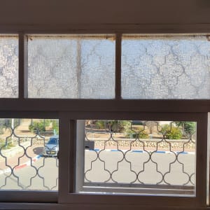 חלון עם וילון תחרה לבן בחלק העליון