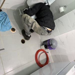 אדם עובד על תיקון אסלה בחדר אמבטיה