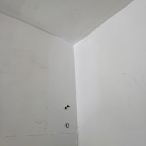 קיר עם חורים ותיקוני איטום בפינה