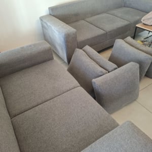 ספות אפורות עם כריות מונחות על הרצפה