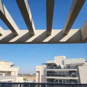 רשת יונים מותקנת על מרפסת בניין