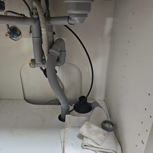 צנרת מתחת לכיור עם פומפה ומטלית