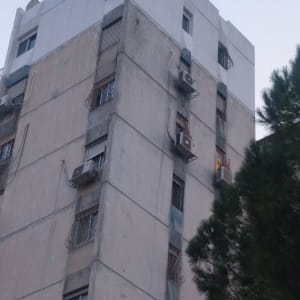 בניין גבוה עם מזגנים מותקנים על הקירות החיצוניים