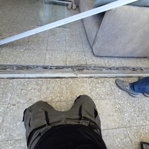 תיקון מסילה לדלת אלומיניום עם כלים על הרצפה
