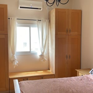 חדר שינה עם ארונות עץ ומיטה