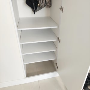 ארון פתוח עם מדפים לבנים ודלתות צירים