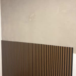 קיר צבוע בצבע בהיר עם לוחות עץ אנכיים