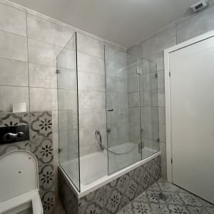 חדר אמבטיה עם מקלחון זכוכית ורצפת אריחים מעוצבת