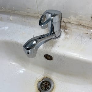 ברז כרום על כיור עם סתימות ולכלוך