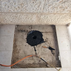 אזור ריצוף עם חומר איטום שחור וכלי עבודה