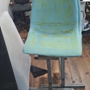 כיסא מרופד בתהליך עבודה בסדנה עם כלים מסביב