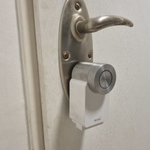 מנעול חכם מותקן על דלת עם ידית מתכת