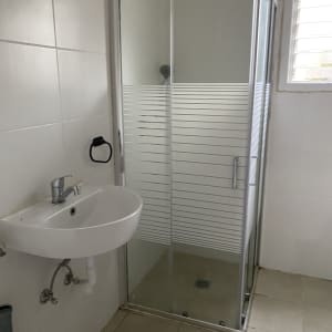 מקלחון זכוכית, כיור וברז בחדר אמבטיה