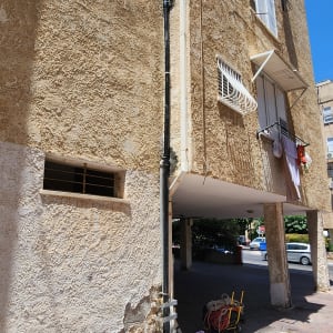 צינור שחור מחובר לקיר בניין עם עגלת כלים