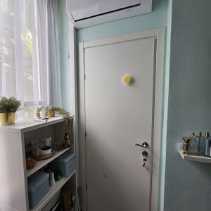 מזגן מותקן מעל דלת בחדר עם קיר תכלת