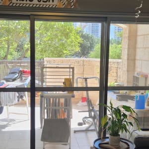 מרפסת עם דלת זכוכית, צמחים וכביסה תלויה