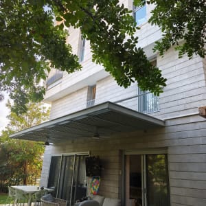 מרפסת עם ריהוט גן ועצים מסביב