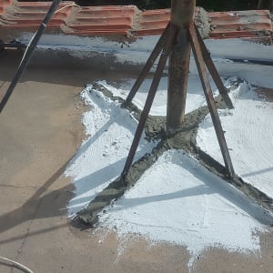 צינור מתכת חלוד על גג עם חומר איטום לבן