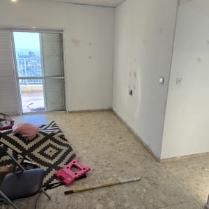 חדר עם קירות צבועים וכלי עבודה לצביעה על הרצפה