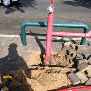 כלי עבודה ליד צינור מים אדום בחפירה