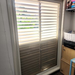 חלון זכוכית עם תריסים סגורים בחדר מואר