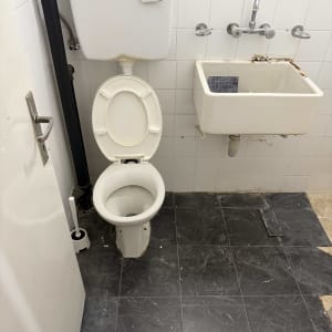 שירותים וכיור בחדר אמבטיה עם רצפה שחורה