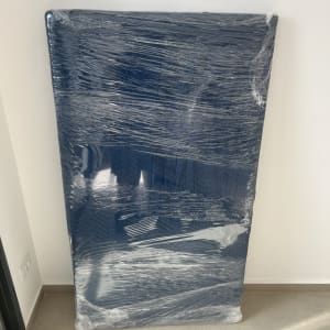 חפץ עטוף בניילון מונח על הרצפה ליד קיר