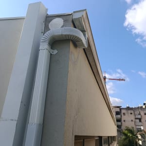צינור ניקוז על גג בניין עם שמיים כחולים