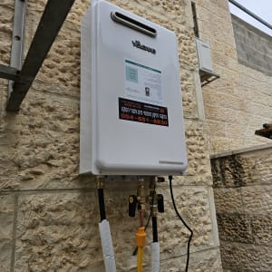 מחמם מים גז מותקן על קיר אבן חיצוני