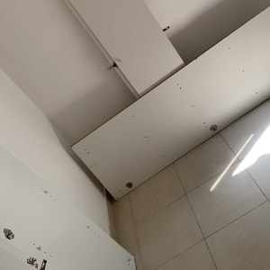 לוחות עץ לבנים עם צירים וברגים על רצפה