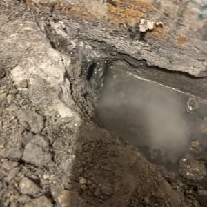 מים דולפים מתוך קיר עם סדקים ועפר