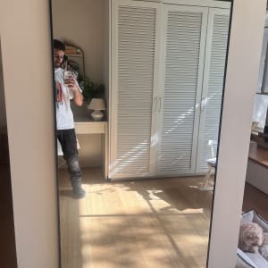 מראה גדולה על קיר עם השתקפות של אדם