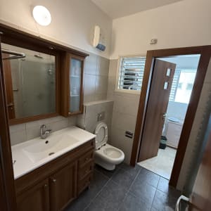 חדר אמבטיה עם כיור, שירותים ודלת פתוחה