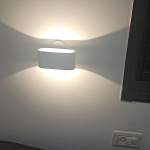 מנורת קיר דולקת ושקע חשמל בקיר