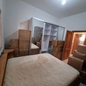 חדר עם קרטונים ומזרן, מוכן להובלה