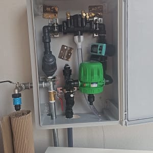 מערכת השקיה עם שסתומים וצינורות בתוך ארון