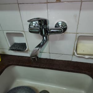 ברז כרום מותקן מעל כיור מטבח לבן