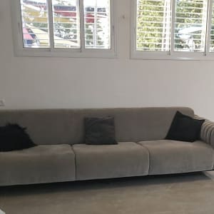 ספה אפורה עם כריות בחדר מואר