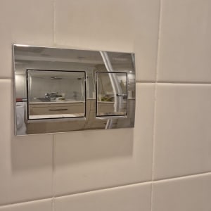 לחצן הדחה על קיר אריחים לבנים