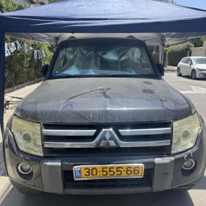 רכב מלוכלך תחת גזיבו כחול