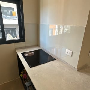 משטח עבודה עם כיריים וקיר זכוכית במטבח