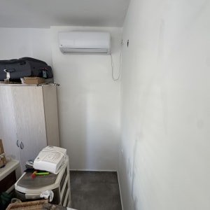 קיר צבוע עם מזגן וחפצים על ארון