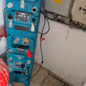 מכונה כחולה עם חיבורים חשמליים וציוד ייבוש