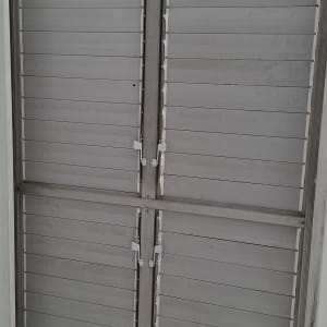 תריסים סגורים על חלון עם מסגרת מתכת
