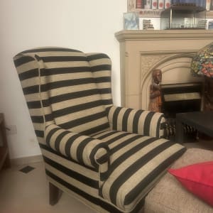 כורסה מפוספסת ליד אח עם קישוטים