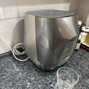 מכונת מים על משטח מטבח עם כוס פלסטיק