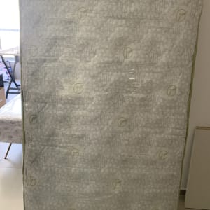 מזרן עומד בחדר עם רהיטים ברקע