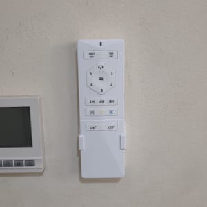 שלט רחוק לבן עם כפתורים לשליטה במאוורר ותאורה