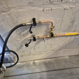 צינורות גז עם ברזים על קיר בטון