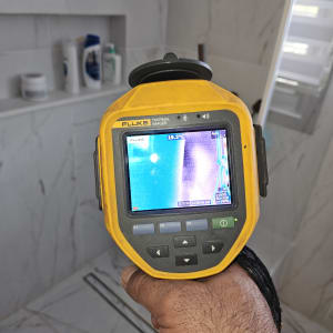 מצלמה תרמית ביד בודקת נזילות בחדר אמבטיה